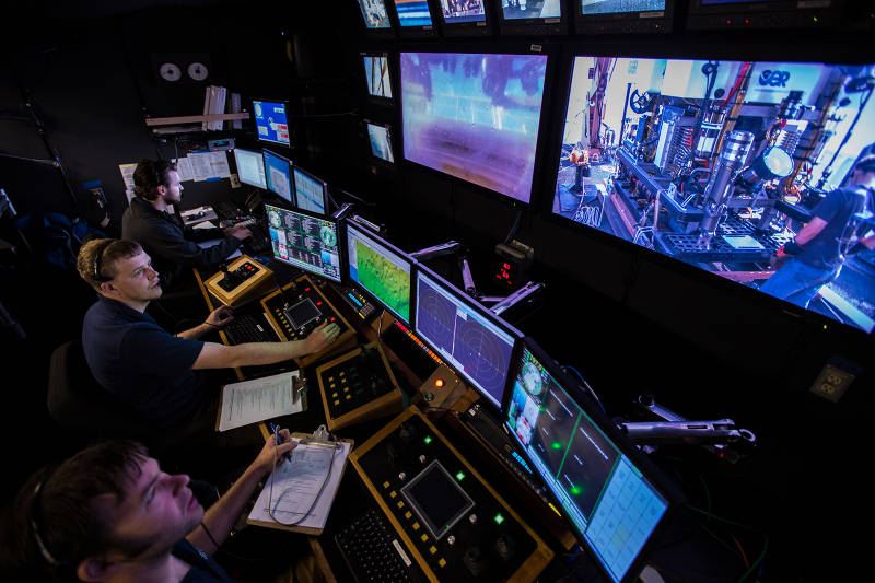 The Okeanos Explorer control room just before the start of an ROV dive. The control room is where the ROV pilots, the science leads, and other expedition personnel work during an ROV dive.