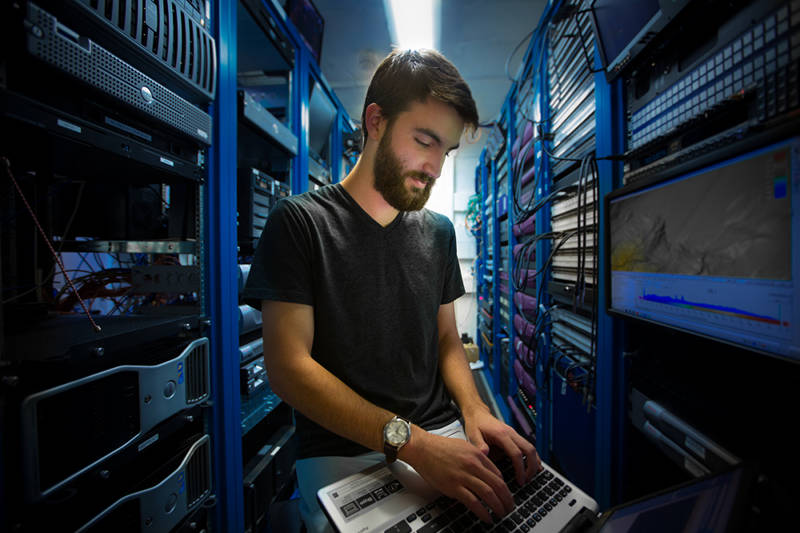Data management intern Dan Bolan works in the rack room, the computer system hub for the ship.