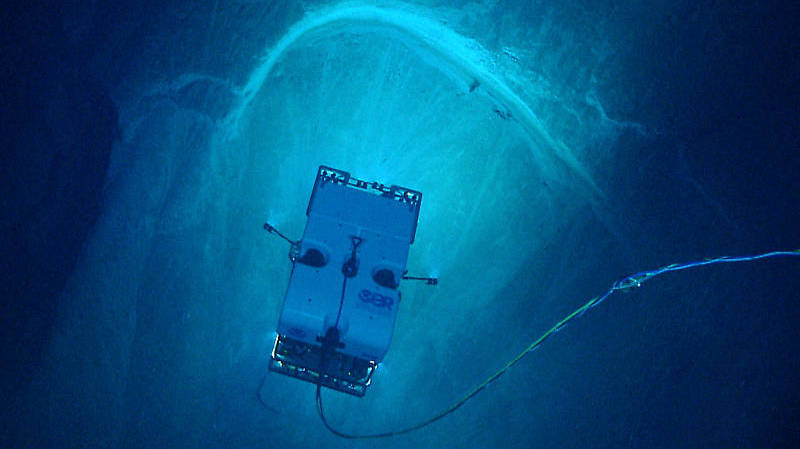 Remotely operated vehicle Deep Discoverer images a spectacular arcuate, headwall scarp measuring 20 meters (66 feet) across, seen in the carbonate Juana Diaz Formation, Guayanilla Canyon, to the south of Puerto Rico. The image shows that the limestone below the arcuate or curved scarp has broken away and slipped down the slope. Headwall scarps such as this one provide evidence of slope instability in the form of landslides and/or the bare rock faces left behind after a landslide has occurred. Image courtesy of NOAA Ocean Exploration, Exploring Puerto Rico’s Seamounts, Trenches, and Troughs.