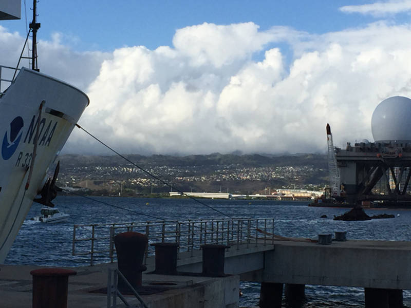 NOAA Ship Okeanos Explorer moored pier side Ford Island with the final resting place of the USS Utah visible just above the waterline