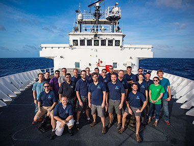 The at-sea team poses for a picture on the bow of the ship.