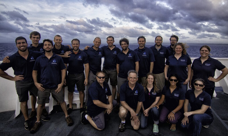 Getting a picture of everyone involved in an Okeanos Explorer telepresence-enabled cruise is nearly impossible. More than 50 scientists and students participated in Leg 1 of the Deepwater Exploration of the Marianas Expedition from around the world! Many more crew, shore-side technicians, educators, outreach specialists, and others provide critical support to enable the expedition to happen. Here, the shipboard mission team poses for a picture on the bow of the ship before pulling into port in Saipan to bring Leg 1 of the expedition to a close.