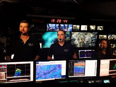 Geology Lead Scientist, Dr. Del Bohnenstiehl (left), and Biology Science Lead, Dr. Scott France (middle), answer questions during the first-ever NOAA Ship Okeanos Explorer Facebook Live interaction. Web coordinator, Amy Bowman (right) helped field questions from the public during this exchange.