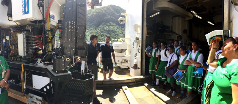 Levi Unema and Sean Kennison, remotely operated vehicle (ROV) engineers with the Global Foundation for Ocean Exploration, teach students in American Samoa about ROV Deep Discoverer during a ship tour.