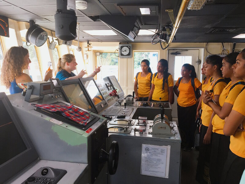 Engaging with local students is a key component of Okeanos Explorer missions. In this photo, Expedition Coordinator Kasey Cantwell teaches a group of students from American Samoa about the bridge of the ship during a tour.