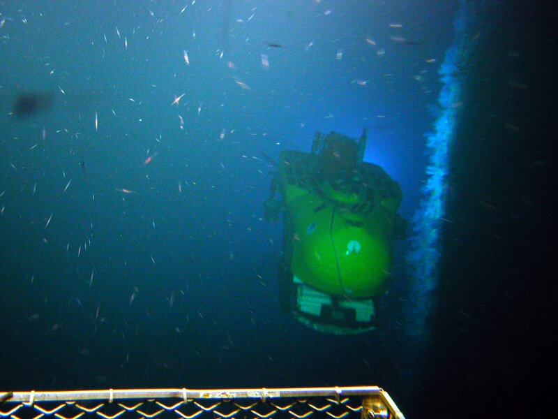 A Pisces submersible moves along the sheer cliff-face at Jarvis Island, as photographed by the other Pisces submersible.