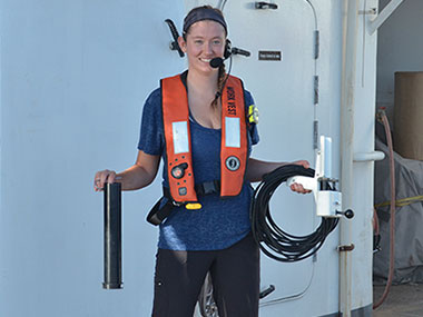 Mapping Watchstander, Neah Baechler, prepares to put the expendable bathythermograph (XBT) equipment away after deploying an XBT. XBTs are launched every ~2-6 hours to acquire temperature data of the water column down to 760 meters (2,493 feet). These data are used to estimate water column refraction required for multibeam sonar data.