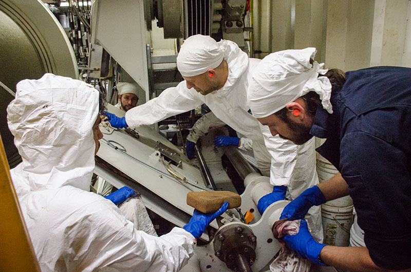 The remotely operated vehicle (ROV) team cleans the winch, getting the grease off it to prevent grit and dirt from building up during the time the vehicle is not being used in between ROV cruises.