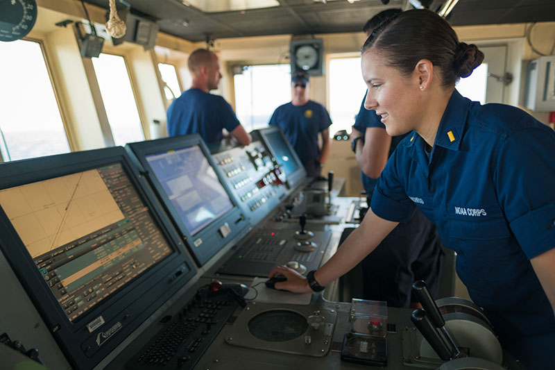 ENS Brianna Pacheco using the ship's Electronic Chart Display Information System (ECDIS) to navigate the ship. ECDIS is an “industrial-sized” navigation app that encompasses electronic navigation charts, GPS, gyrocompass, radar, depth sounder, autopilot, automatic route safety scanning programs and a host of other electronic tools.