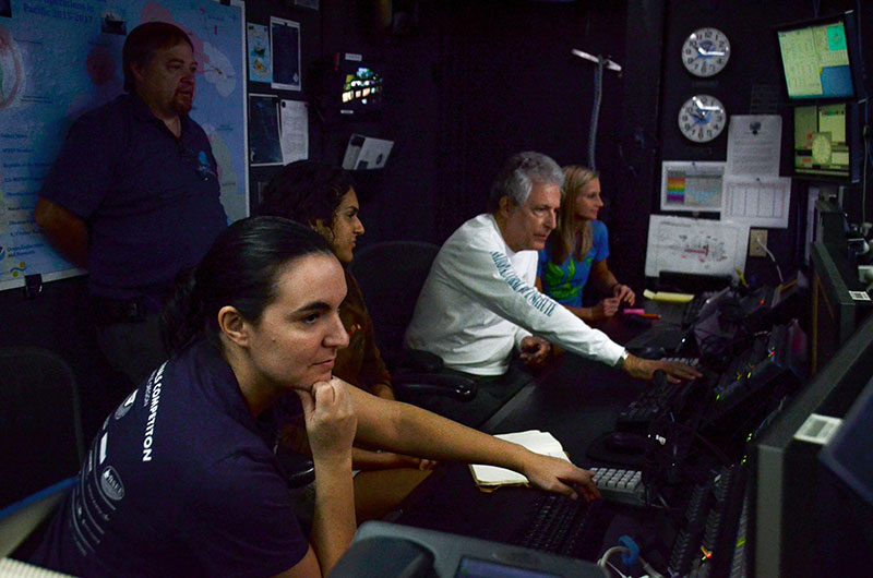 Alex and other members of the on-ship team receive training from Global Foundation for Ocean Exploration engineer Roland Brian in the Okeanos Explorer's control room.