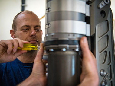 Global Foundation for Ocean Exploration ROV engineer, Dan Rogers, performs maintenance on Deep Discoverer’s starboard lower lightbar swingarm.