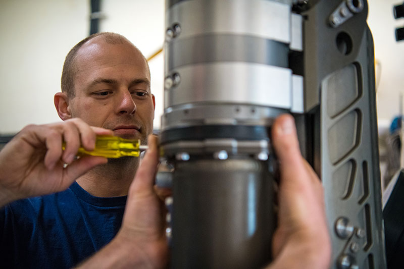 Global Foundation for Ocean Exploration ROV engineer, Dan Rogers, performs maintenance on Deep Discoverer’s starboard lower lightbar swingarm.