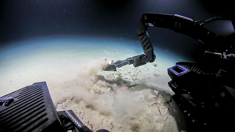 Remotely operated vehicle (ROV) Deep Discoverer collects a geological sample of the seafloor sediment using the scoop tool. Collecting these samples allows scientists to learn more about geologic features in the region.