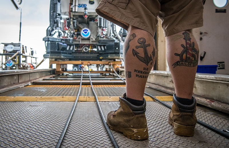 Pete’s tattoo of an anchor on his left leg signifies him being part of the deck department. It also represents him being hooked into the sailing industry. The lighthouse on his right leg identifies Pete as a member of the deck department, as well as symbolizing guidance for sailors on their way home.