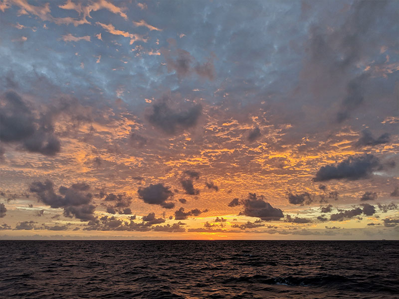 Looking out at the final sunset on board from the bow of the ship.