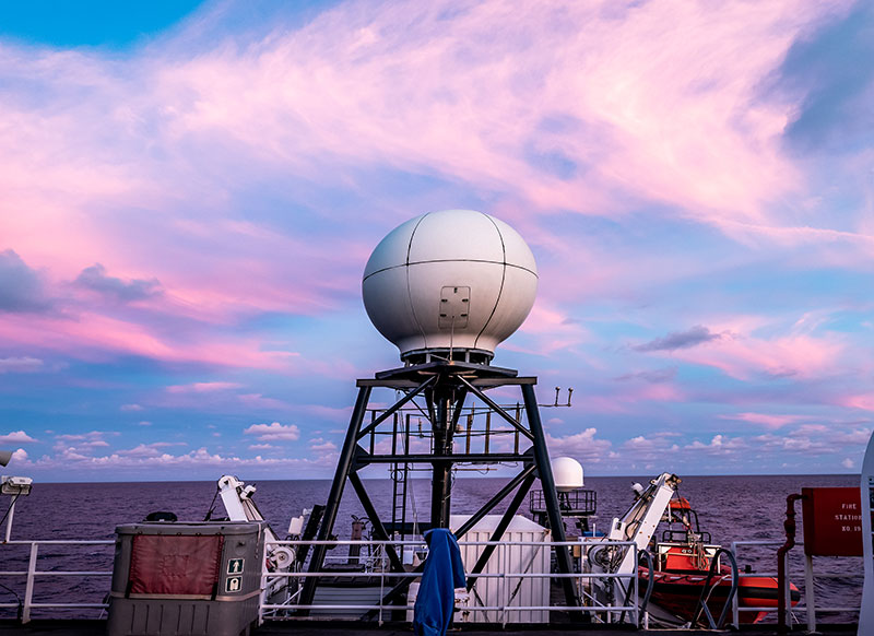 The sun sets over the VSAT or Very Small Aperture Terminal antenna that allows for real-time sharing of our exploration data and live video through telepresence. Image courtesy of Art Howard, Global Foundation for Ocean Exploration.