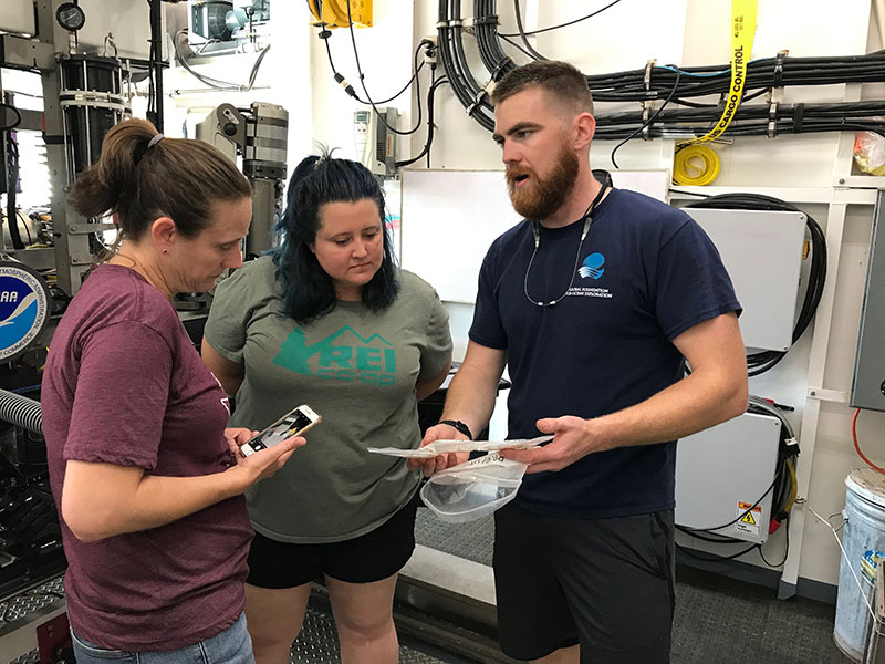 Lars Murphy reviews one of the new tools added to the remotely operated vehicle Deep Discoverer over the winter with Science Leads Alexis Weinnig and Amy Wagner as they discuss how to approach sampling operations during this expedition.