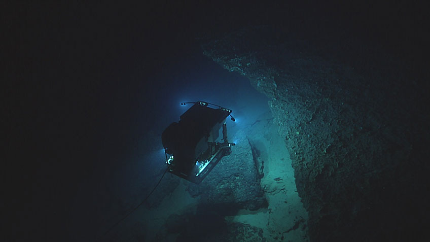 Imaged by its camera sled ROV Seirios, ROV Deep Discoverer explores some interesting, yet potentially dangerous geology, on the Pourtalès Terrace during Dive 10 of the 2019 Southeastern U.S. Deep-sea Exploration.