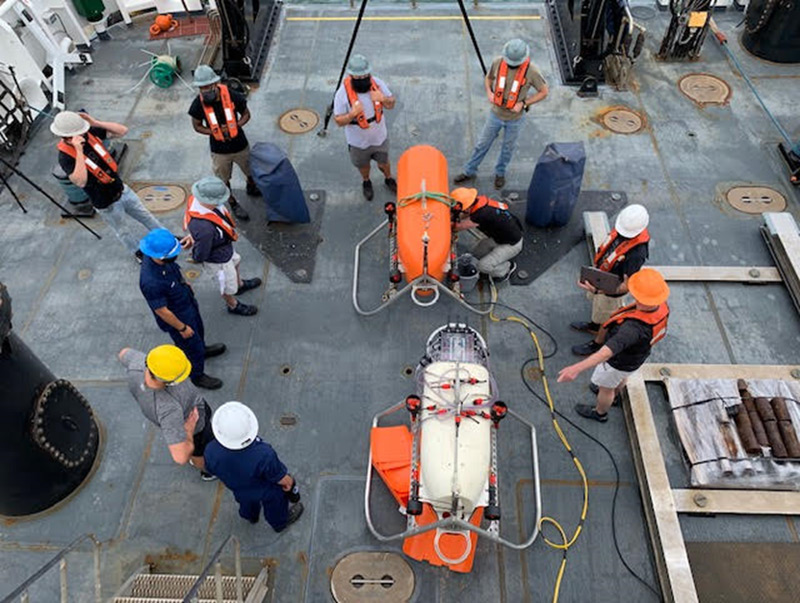 May 13, 2021. NOAA Ocean Exploration mission personnel, engineers from NASA Jet Propulsion Laboratory and Woods Hole Oceanographic Institution (WHOI), and crew of NOAA Ship Okeanos Explorer prepare to field test WHOI’s autonomous underwater vehicle Orpheus