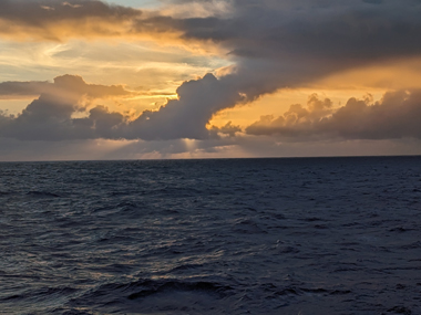 The sun peeks through the clouds over the Pacific Ocean during the Beyond the Blue: Hawai‘i Mapping expedition on NOAA Ship Okeanos Explorer.