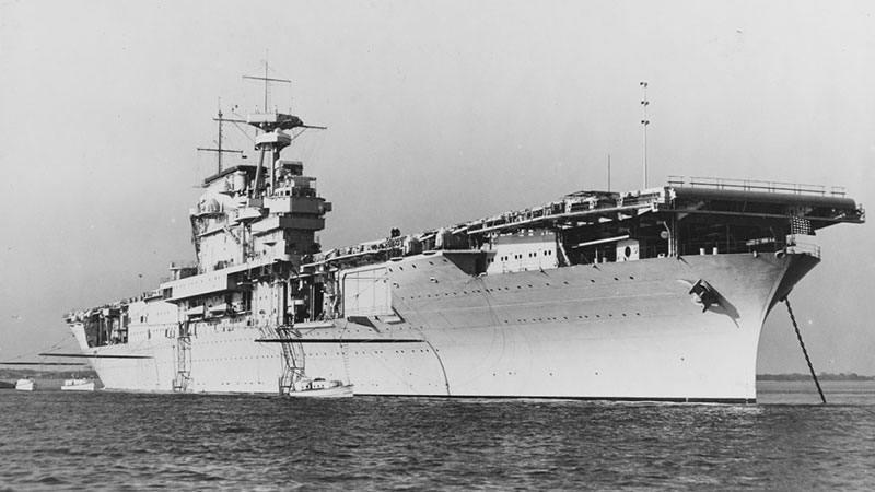 Aircraft carrier at sea with superstructure and antennae.
