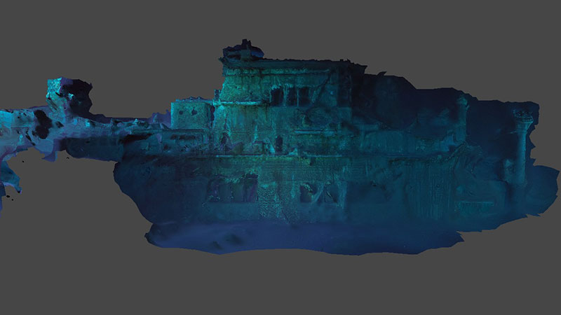 3D model of the sunken Yorktown in blue and teal, with multiple levels and a cylindrical column.