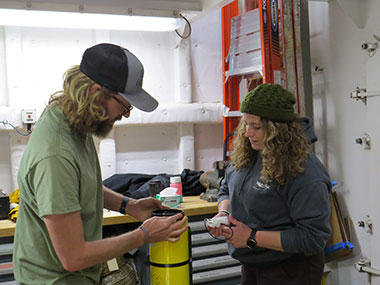 Orca Maritime autonomous underwater vehicle (AUV) operators Chad Nelson and Chrissy Lamendola perform maintenance on the Iver3 AUV during the Seascape Alaska 1: Aleutians Deepwater Mapping expedition.