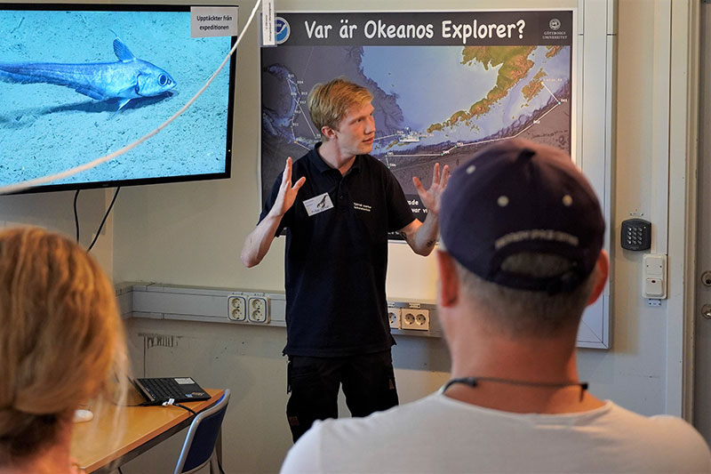 Kommunikatör Christian Nilsson visar besökare en skolästfisk i djuphavsutställningen. 