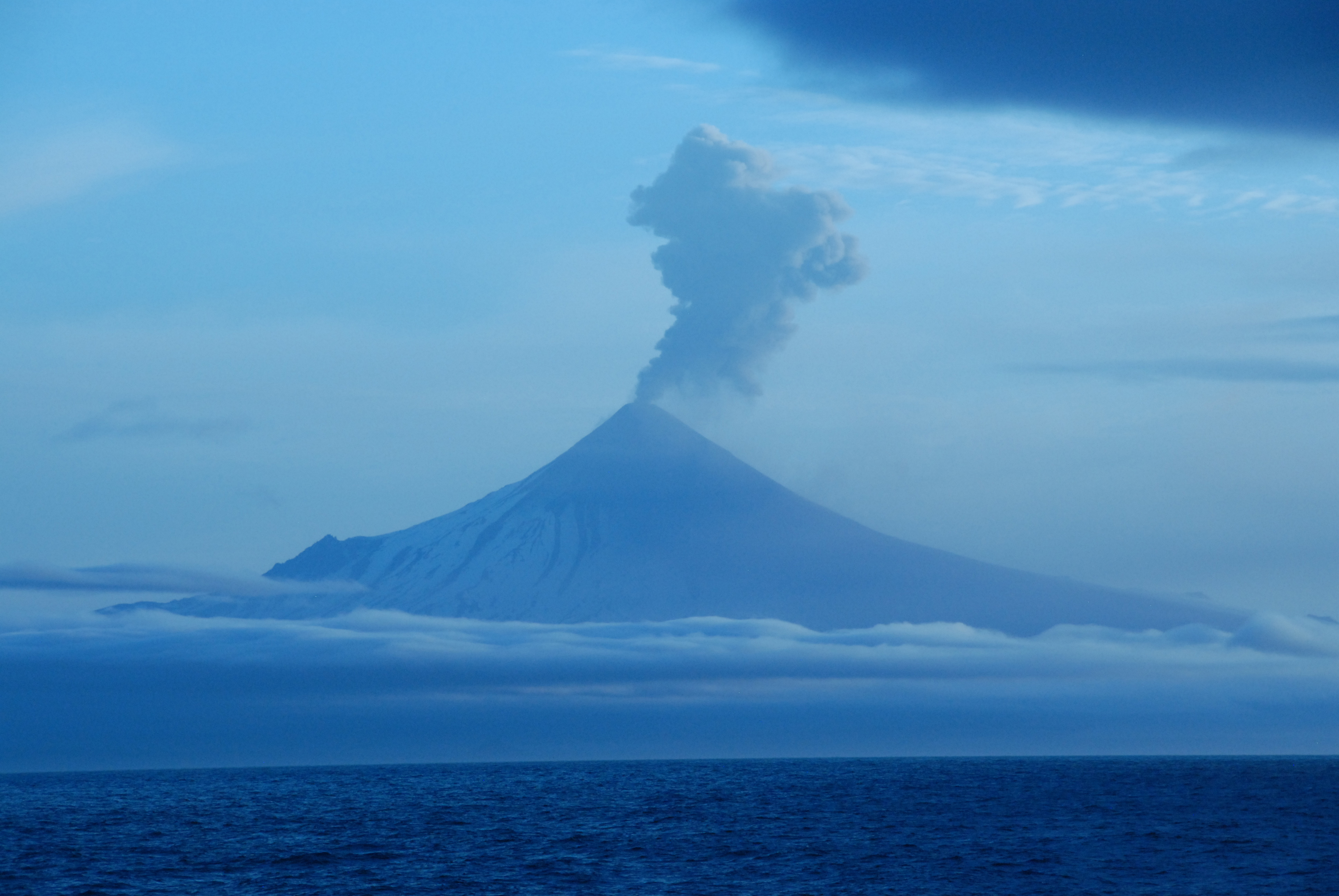Shishaldin Volcano seen here erupting on July 14, 2023, at an alert level of “watch.” This eruption intensified, triggering an alert level of “red/warning” on July 18, 2023.”