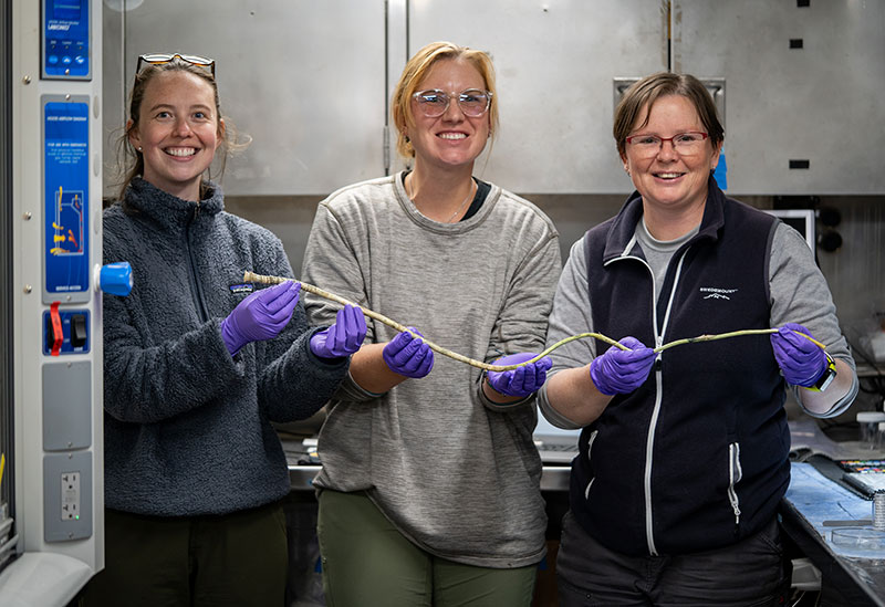 Sample data manager Anna Lienesh, data manager Jennifer Green, and expedition biology science lead Rhian Waller pose with a tubeworm collected during Dive 04 of the Seascape Alaska 3 expedition.