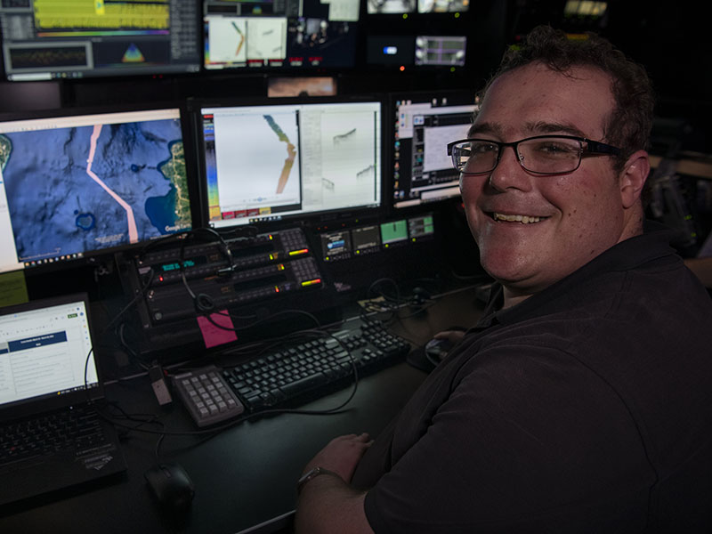 Explorer-in-Training Henry Arndt works on multibeam sonar mapping data processing aboard NOAA Ship Okeanos Explorer. Image courtesy of Caitlin Bailey, GFOE.