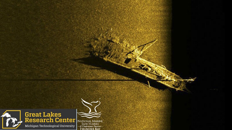 Side scan sonar image of schooner Typo, which collided with steamer W.P. Ketcham in October of 1899. The schooner, which was carrying a cargo of coal, was rammed in the stern. The sonar image shows the bow and upright foremast, cargo hatches across Typo’s deck, and the broken stern with a pile of spilled coal. Image Source: Michigan Technological University Great Lakes Research Center. Image courtesy of the Michigan Technological University Great Lakes Research Center. Download larger version (jpg, 561 KB).