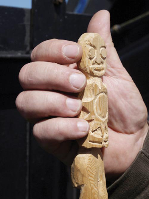 NOAA bosun Bruce Cowden holds one of his carved 'good luck' Tiki dolls, which are usually strapped to the ROV frame.